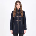 A woman modeling a dark navy blue coat with brown leather-like doggle straps and silver buckles, set against a plain white studio background.